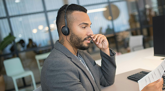 man on headset reads document